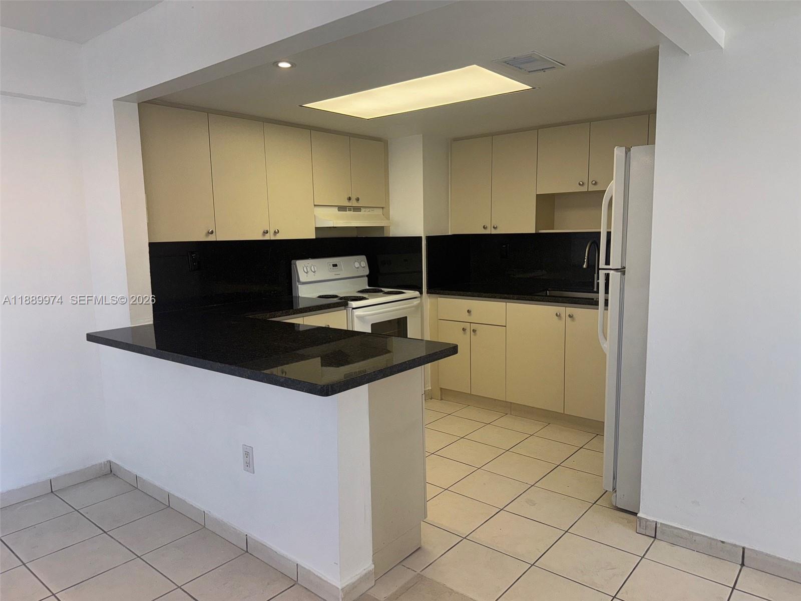 3945 Southwest 89th Avenue, Unit 201 Miami, FL 33165 - Photo 17 of 24 a kitchen with granite countertop a sink and a stove