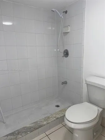 a bathroom with a granite countertop toilet and a sink