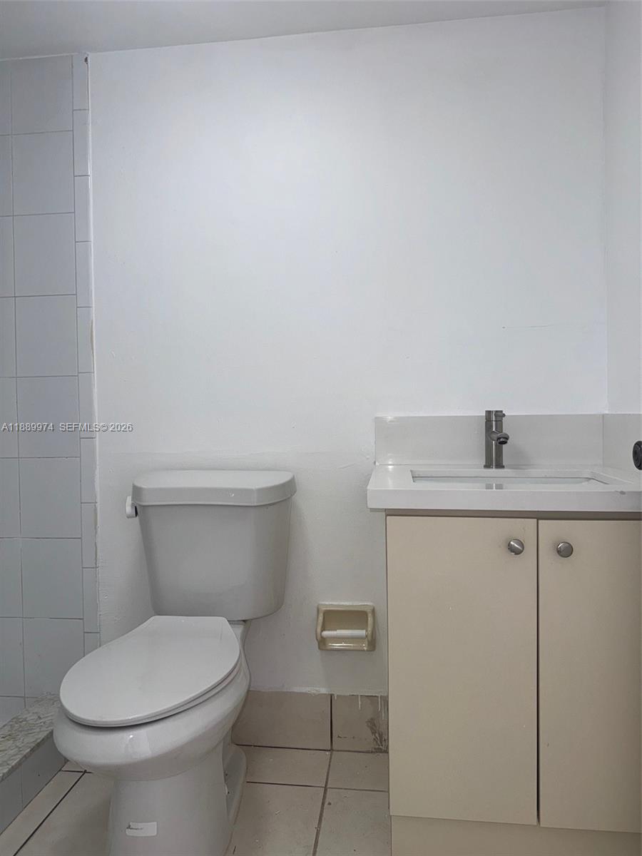 3945 Southwest 89th Avenue, Unit 201 Miami, FL 33165 - Photo 21 of 24 a bathroom with a granite countertop toilet and a sink