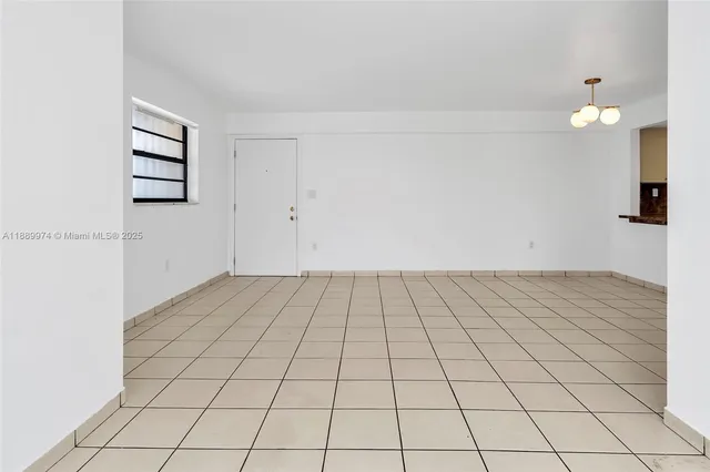 an empty room with a white cabinet and a rug