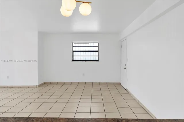 an empty room with a white walls and a window