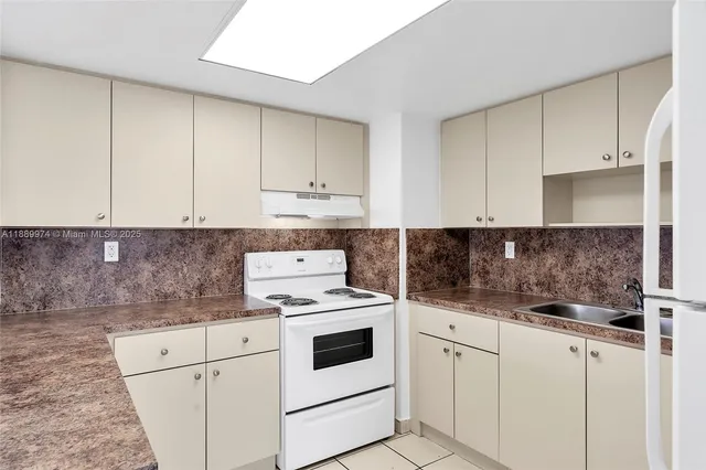 a kitchen with granite countertop white cabinets and white appliances