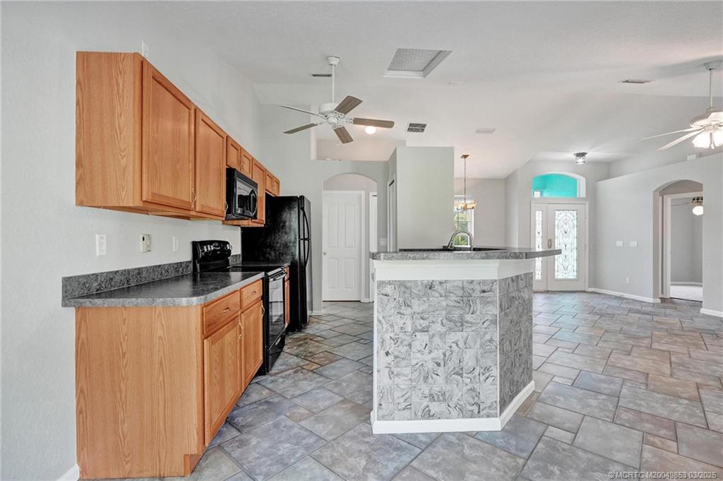 5902 Yucca Drive Fort Pierce, FL 34982 - Photo 12 of 83 a large kitchen with granite countertop a stove a sink dishwasher and a refrigerator