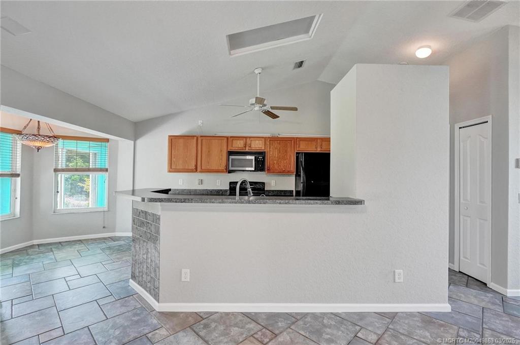 5902 Yucca Drive Fort Pierce, FL 34982 - Photo 13 of 83 a kitchen with stainless steel appliances a sink a stove a refrigerator a window