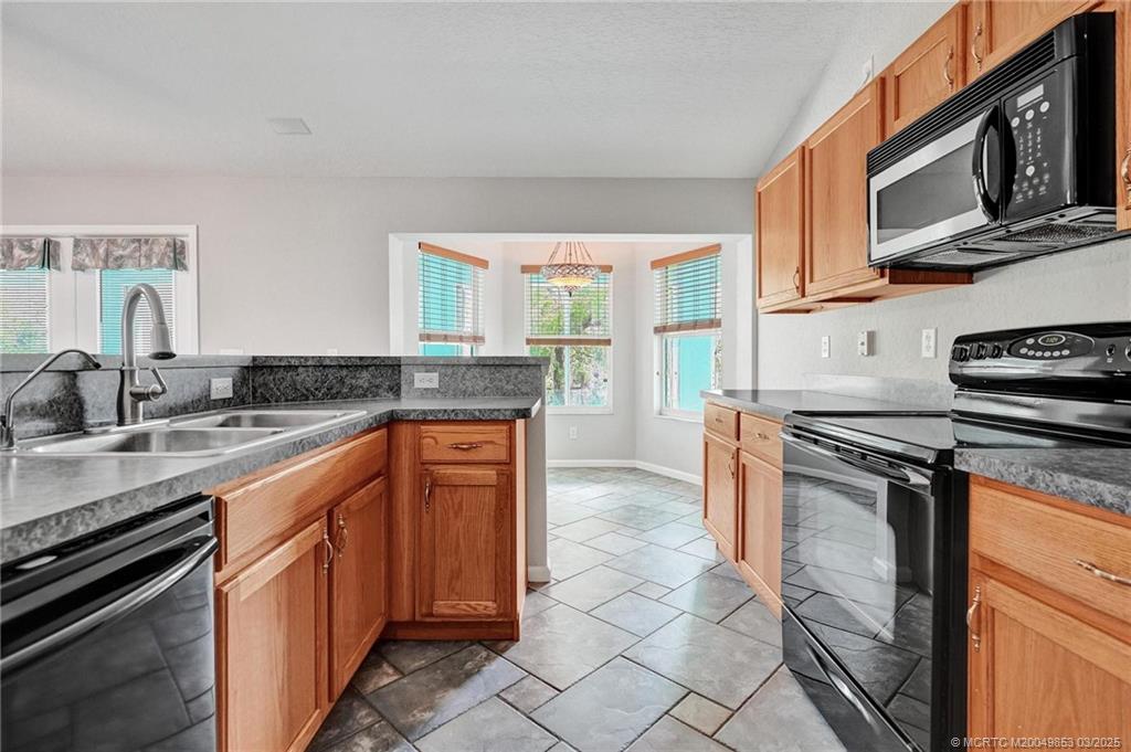 5902 Yucca Drive Fort Pierce, FL 34982 - Photo 15 of 83 a kitchen with stainless steel appliances granite countertop a stove top oven a sink a counter space and cabinets
