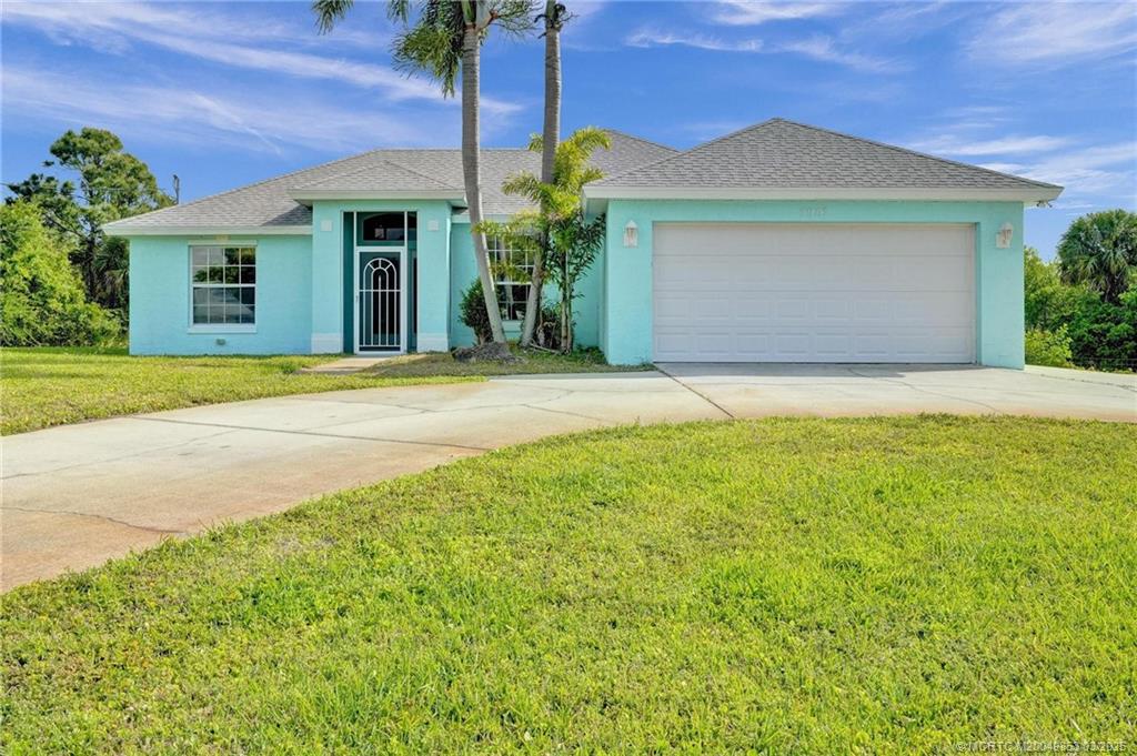 5902 Yucca Drive Fort Pierce, FL 34982 - Photo 4 of 83 a front view of a house with a yard and garage