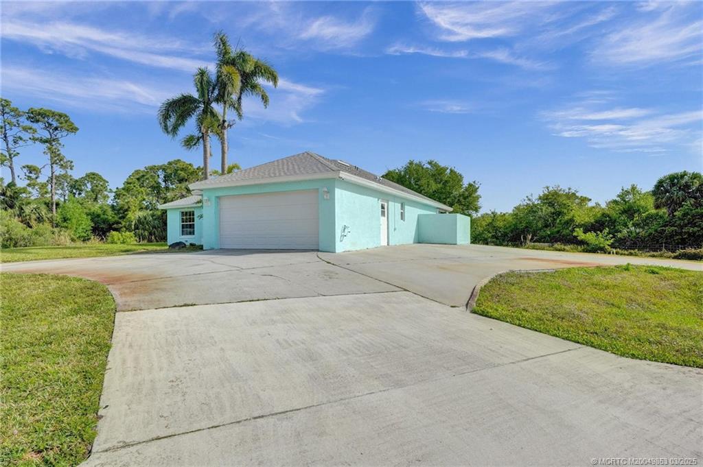 5902 Yucca Drive Fort Pierce, FL 34982 - Photo 5 of 83 a palm tree sitting in front of a house with a big yard