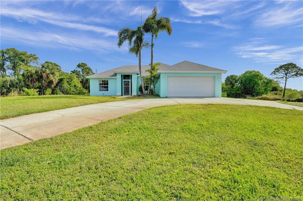 5902 Yucca Drive Fort Pierce, FL 34982 - Photo 60 of 83 a front view of a house with a garden and yard