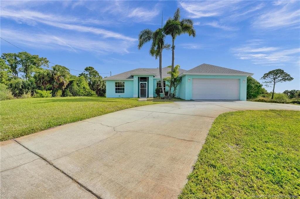 5902 Yucca Drive Fort Pierce, FL 34982 - Photo 61 of 83 a front view of a house with a garden and trees