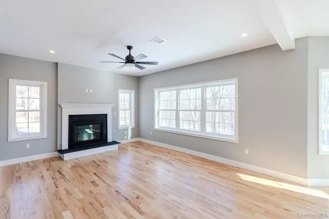 a view of an empty room with a fireplace and a window