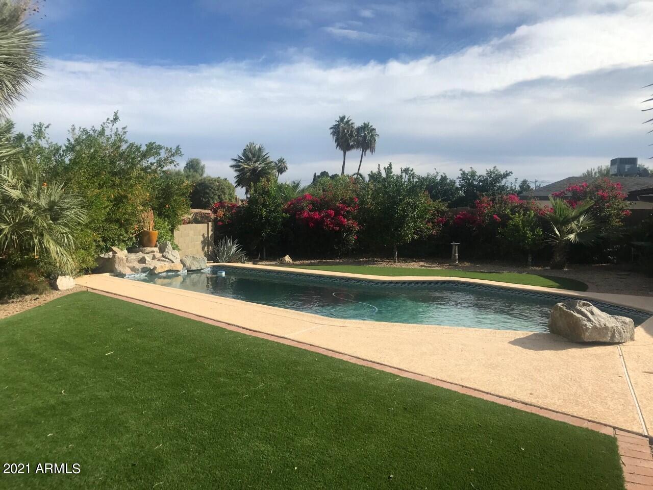 3924 East Yucca Street Phoenix, AZ 85028 - Photo 11 of 17 a view of a swimming pool with a yard