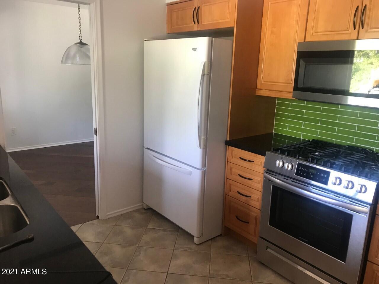 3924 East Yucca Street Phoenix, AZ 85028 - Photo 5 of 17 a kitchen with a refrigerator stove and cabinets