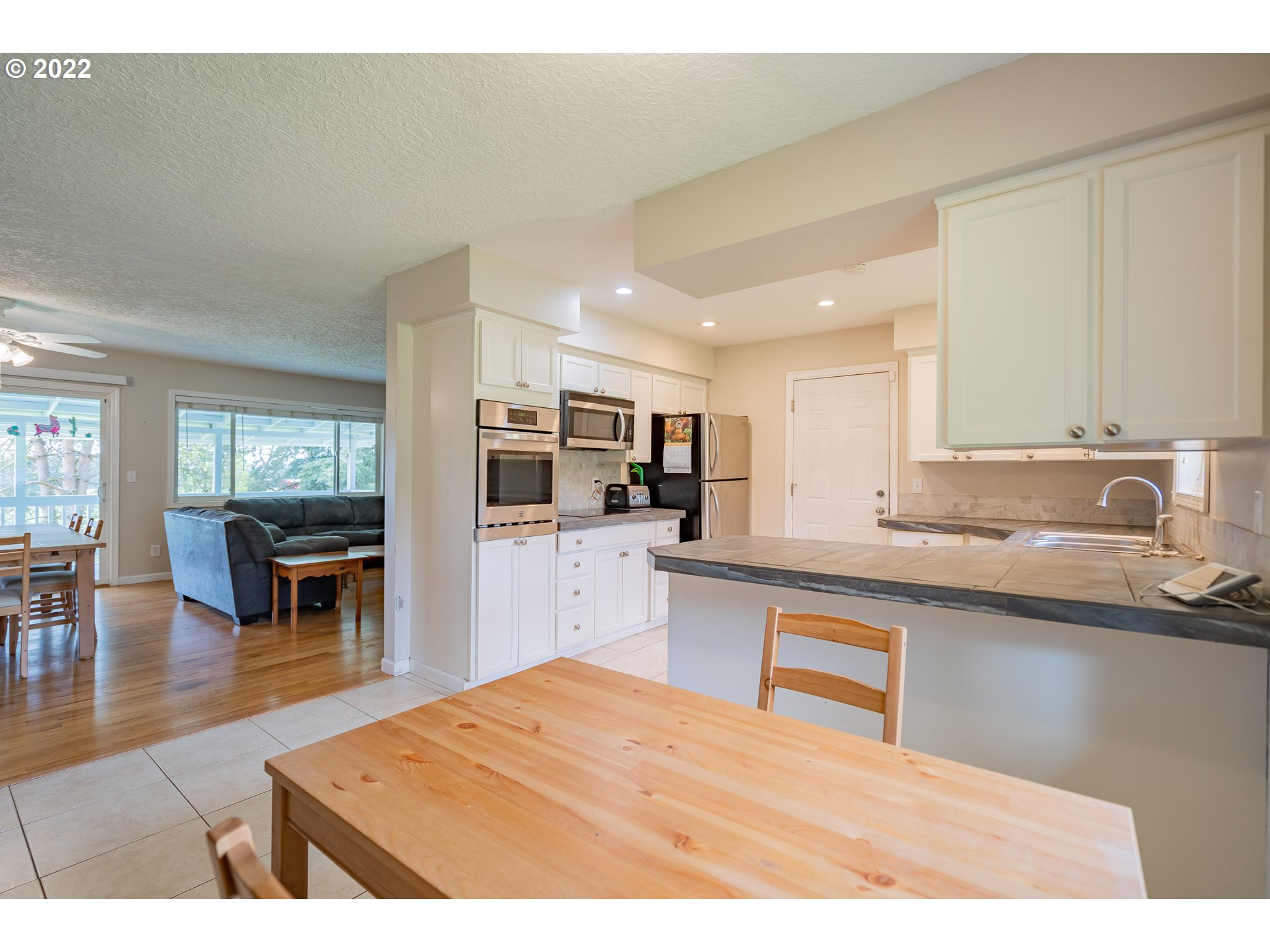 26415 Northeast Brunner Road Camas, WA 98607 - Photo 3 of 32 a kitchen with stainless steel appliances refrigerator sink dining table and chairs
