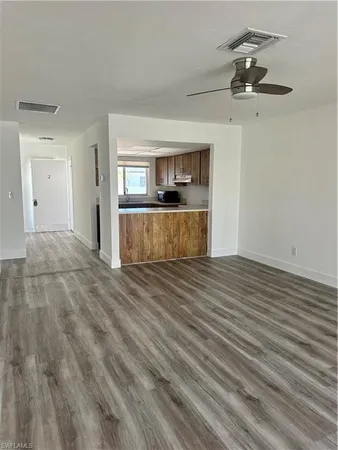 a view of a room with wooden floor and a ceiling fan