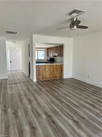 a view of a room with wooden floor and a ceiling fan