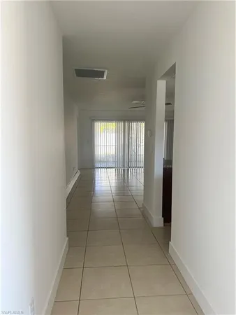 a hallway with a window and chandelier