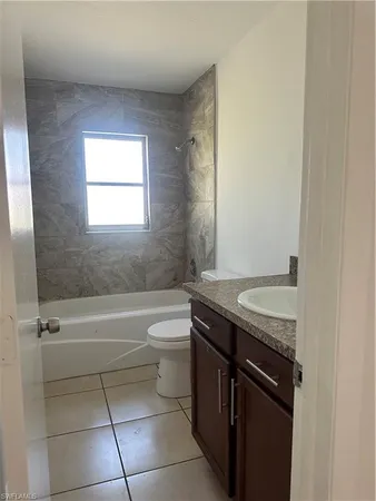 a bathroom with a granite countertop sink toilet and bathtub