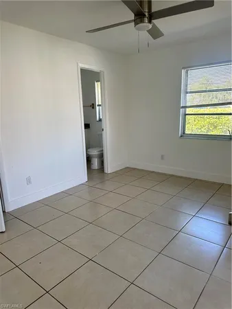 an empty room with a ceiling fan and window