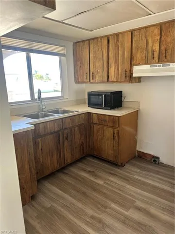 a kitchen with stainless steel appliances granite countertop a sink window and cabinets