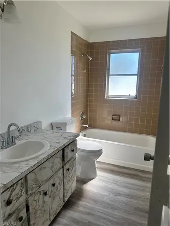 a bathroom with a granite countertop sink toilet and bathtub