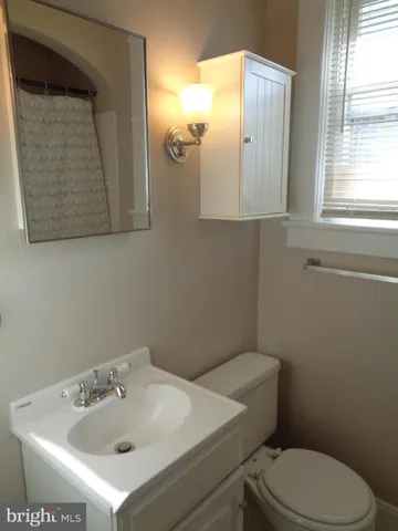 a bathroom with a sink a toilet and mirror