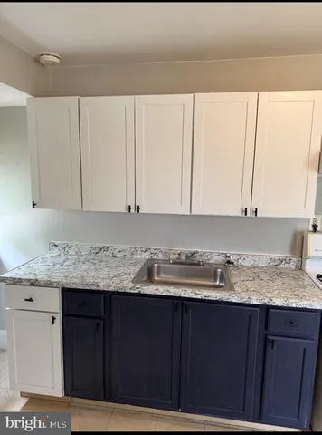 a kitchen with a granite countertop sink and cabinets