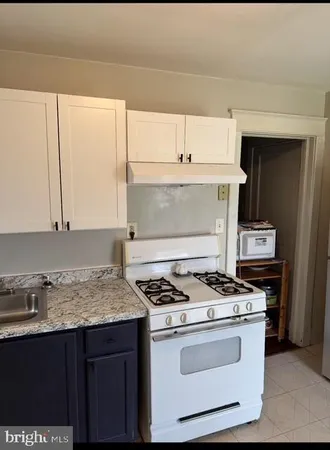 a kitchen with granite countertop a stove and a sink