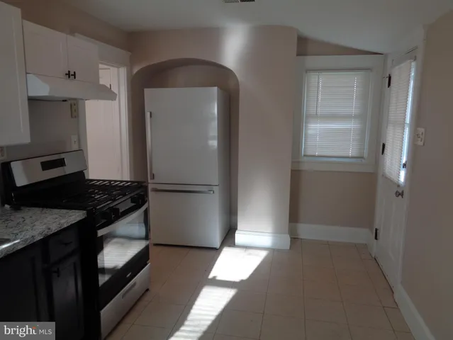 a kitchen with granite countertop cabinets and refrigerator