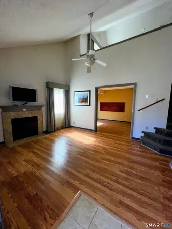 a view of empty room with wooden floor and window