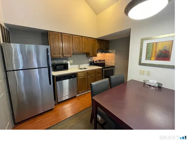 a kitchen with refrigerator cabinets and wooden floor