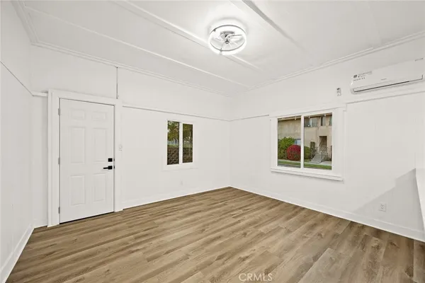 a view of a big room with wooden floor and windows
