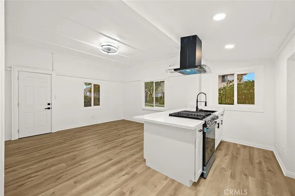 a kitchen with stainless steel appliances granite countertop a stove and a wooden floors