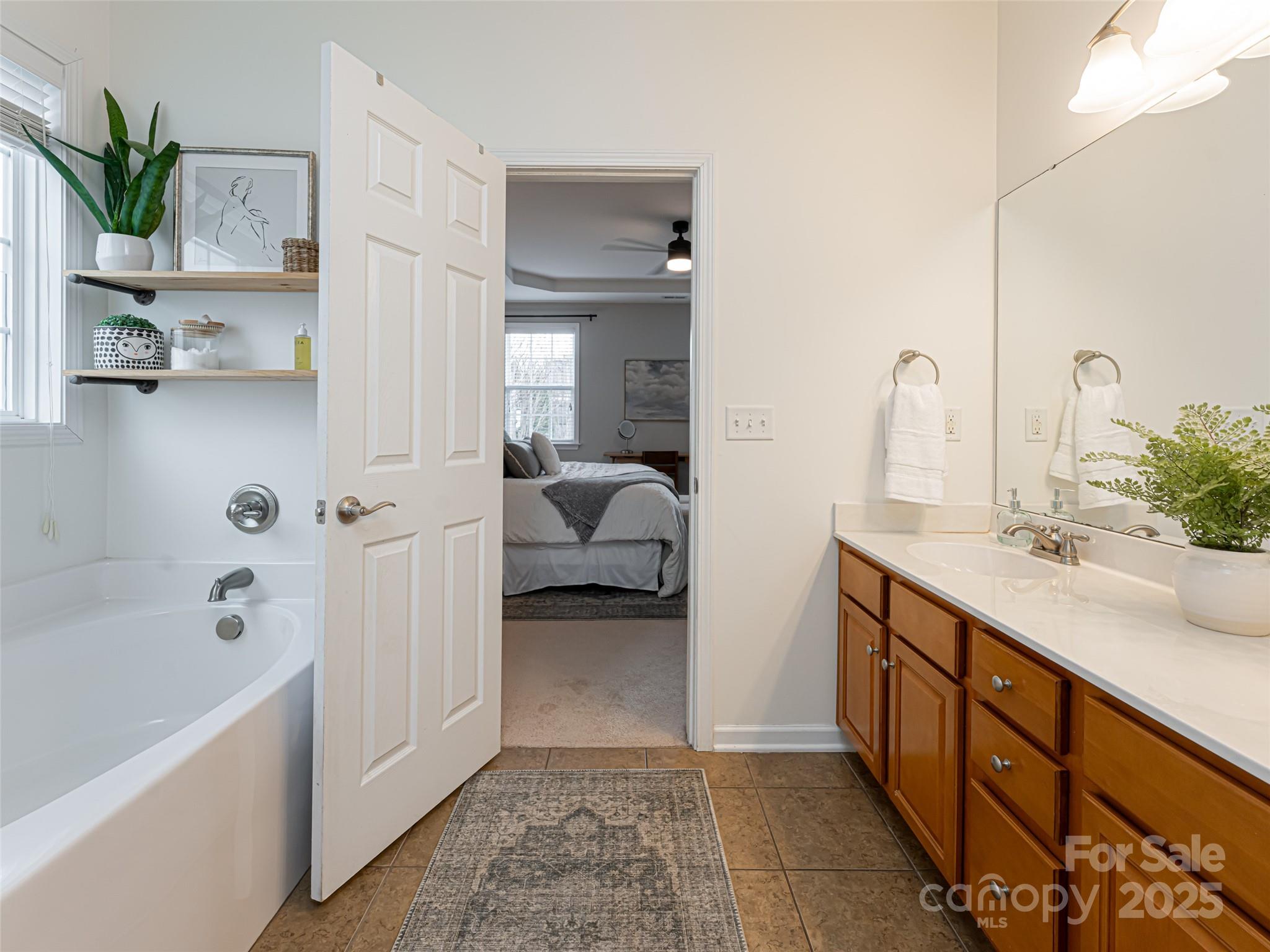 289 Roanoke Road Fletcher, NC 28732 - Photo 21 of 39 a en suite bathroom with a double vanity sink a mirror and a bathtub