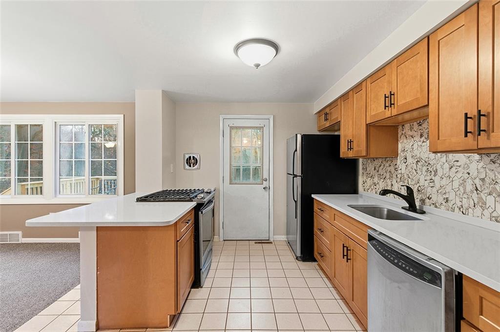 924 Old Hills Road McKeesport, PA 15135 - Photo 13 of 20 a kitchen with stainless steel appliances granite countertop a sink stove and cabinets