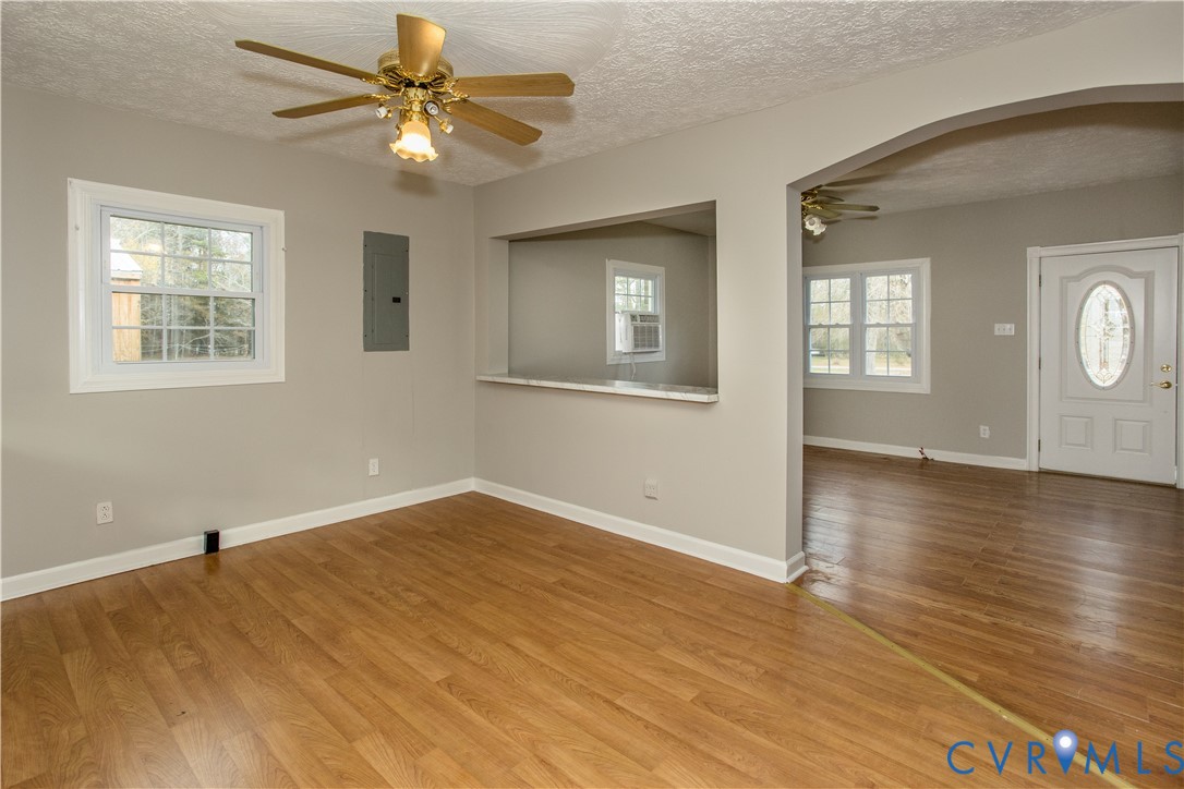 11512 Duncan Road Petersburg, VA 23805 - Photo 8 of 19 an empty room with wooden floor chandelier fan and windows