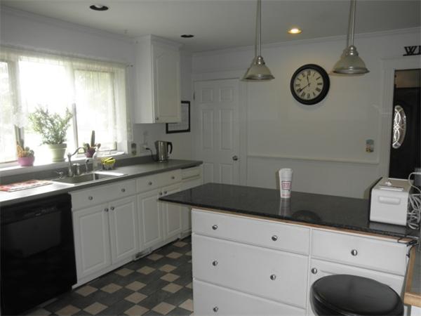 36 Jasper Street Saugus, MA 01906 - Photo 4 of 13 a view of cabinets a sink and a clock on the wall