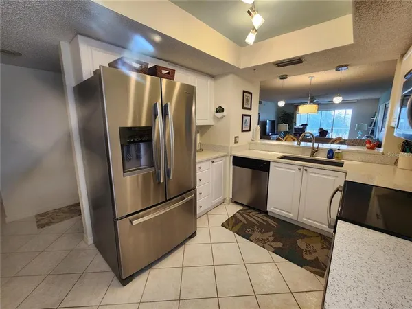a kitchen with stainless steel appliances a sink a stove a refrigerator and cabinets