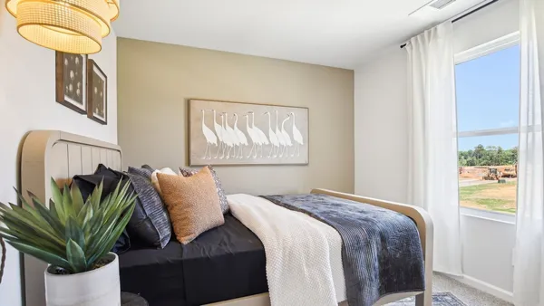 a bedroom with a bed and a painting on the wall