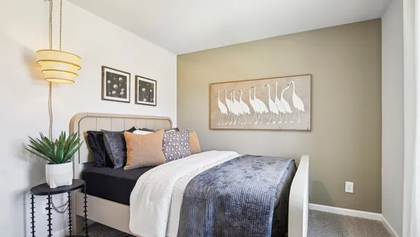 a bedroom with a bed and a potted plant