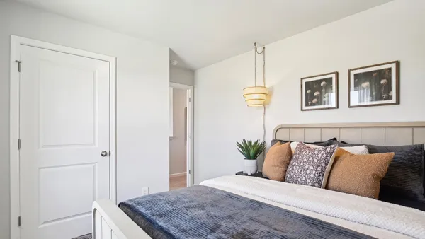 a bedroom with a bed and painting on the wall