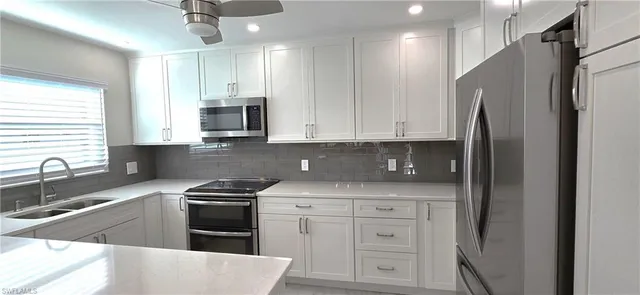 a kitchen with stainless steel appliances granite countertop a refrigerator sink and stove