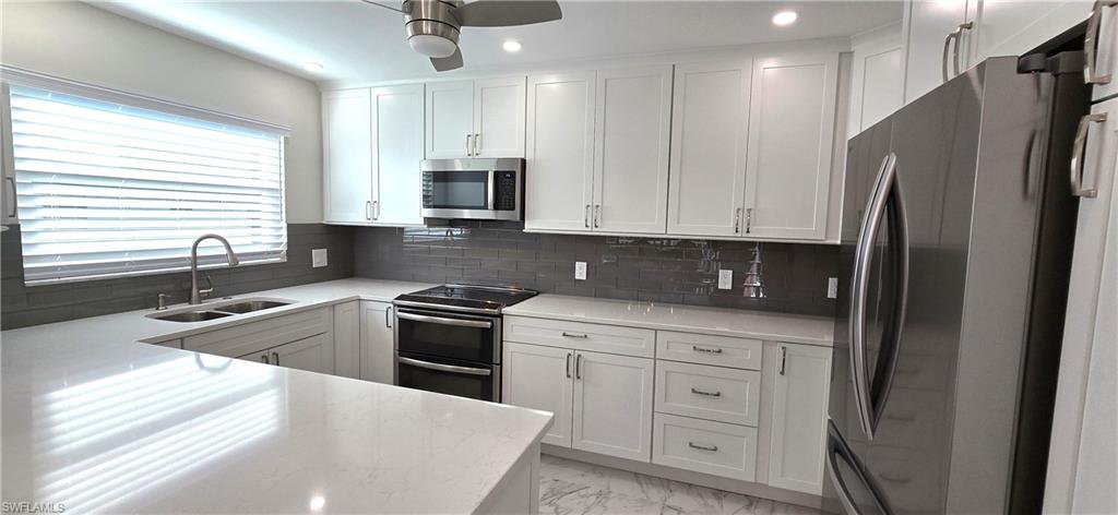 115 Georgetown Boulevard, Unit 115 Naples, FL 34112 - Photo 13 of 32 a kitchen with stainless steel appliances granite countertop a refrigerator sink and stove