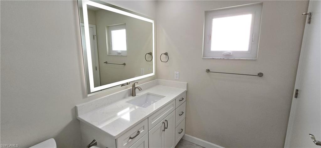 115 Georgetown Boulevard, Unit 115 Naples, FL 34112 - Photo 17 of 32 a bathroom with a sink a vanity and a mirror