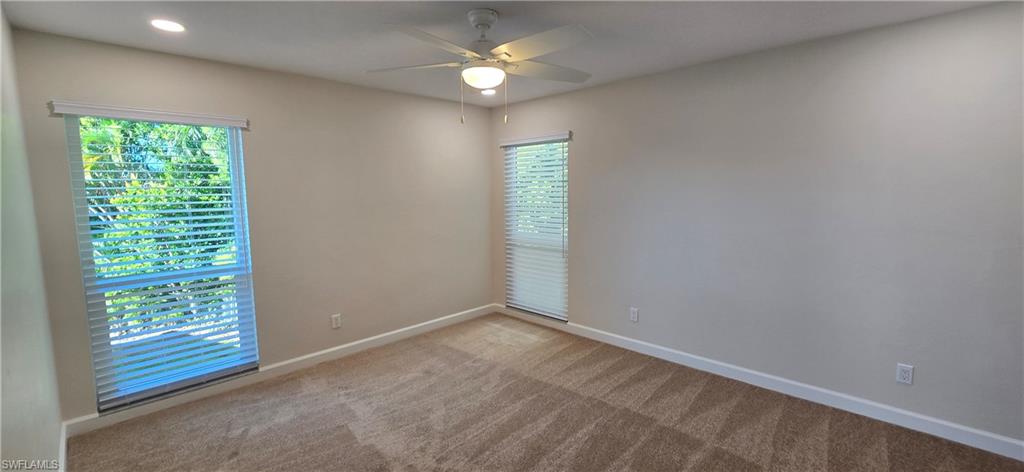 115 Georgetown Boulevard, Unit 115 Naples, FL 34112 - Photo 20 of 32 en empty room with windows and ceiling fan
