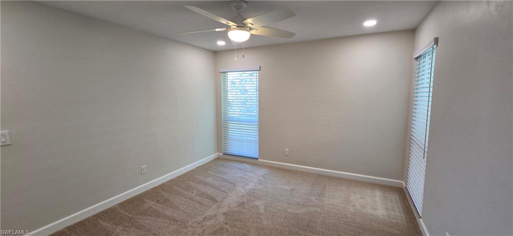 115 Georgetown Boulevard, Unit 115 Naples, FL 34112 - Photo 21 of 32 en empty room with windows and ceiling fan