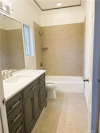a bathroom with a granite countertop sink a mirror and a bathtub
