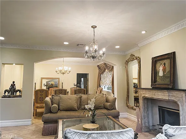 a living room with furniture a fireplace and a chandelier