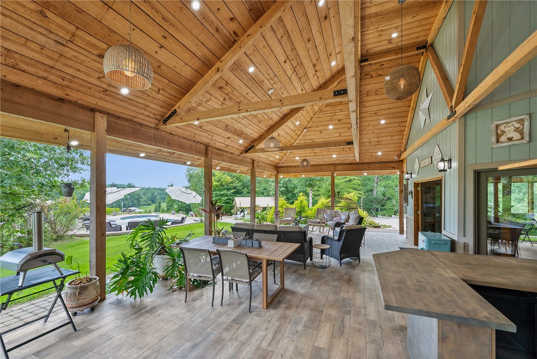 183 Little Eastatoee Road Sunset, SC 29685 - Photo 17 of 50 An inviting covered patio featuring warm wood ceilings, recessed lighting, and a panoramic view of the expansive backyard and pool.