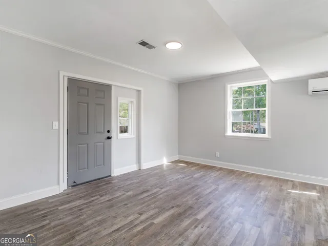 a large kitchen with a center island wooden floor and stainless steel appliances