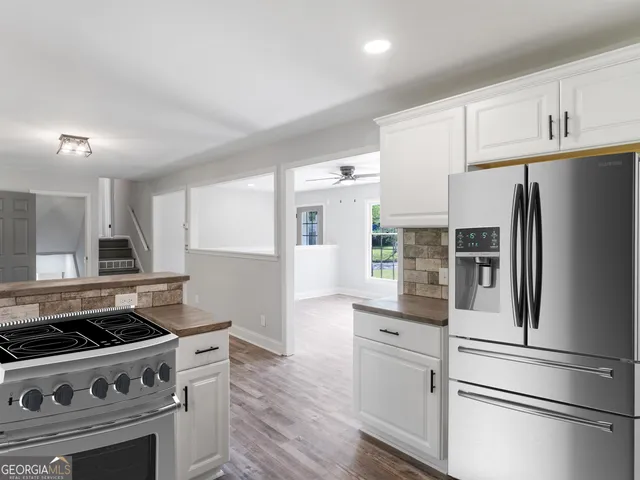 a kitchen with stainless steel appliances granite countertop a sink a stove and cabinets